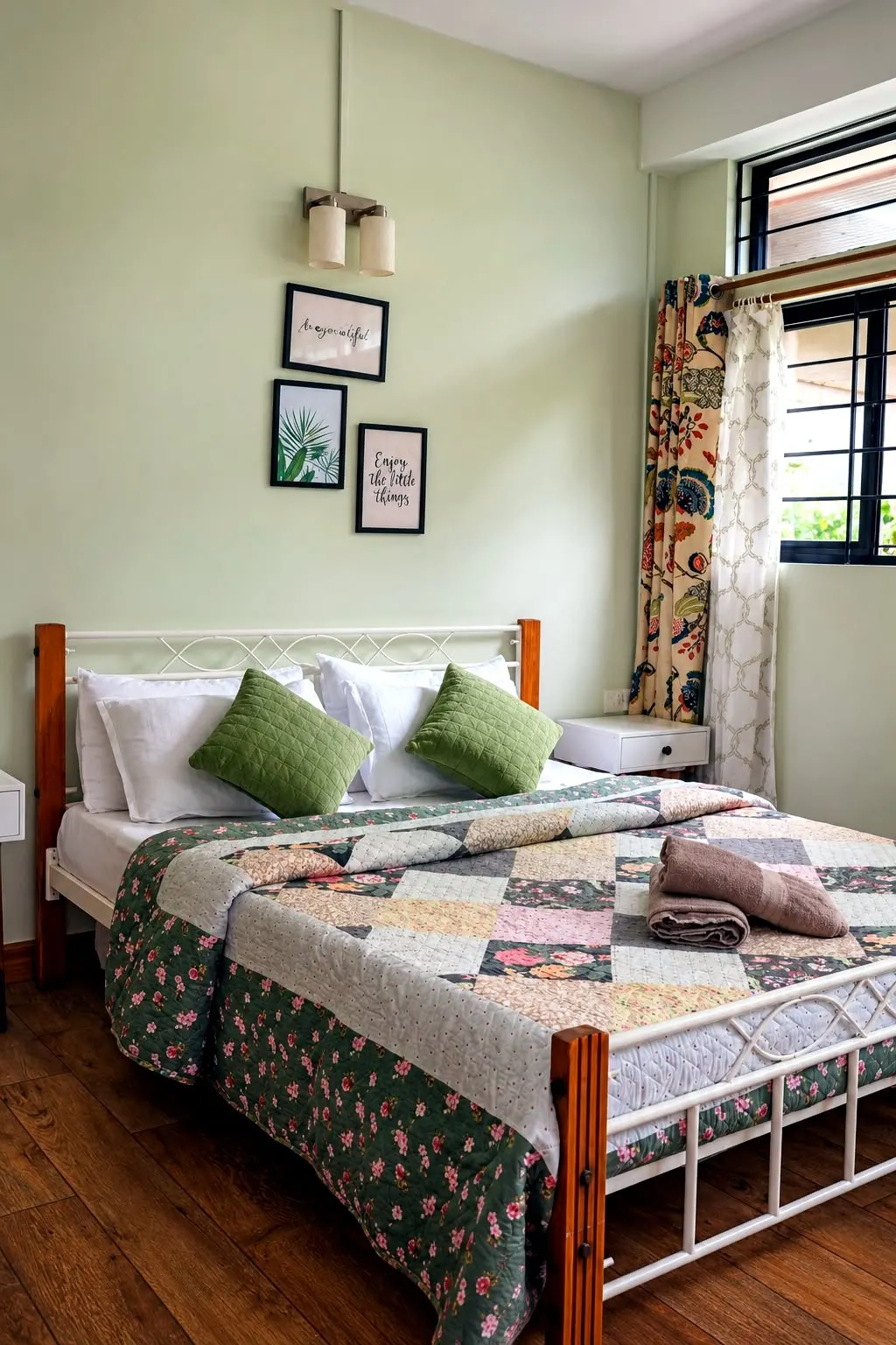 Areca room seen closer, with palm-print art, green cushions and floral curtains